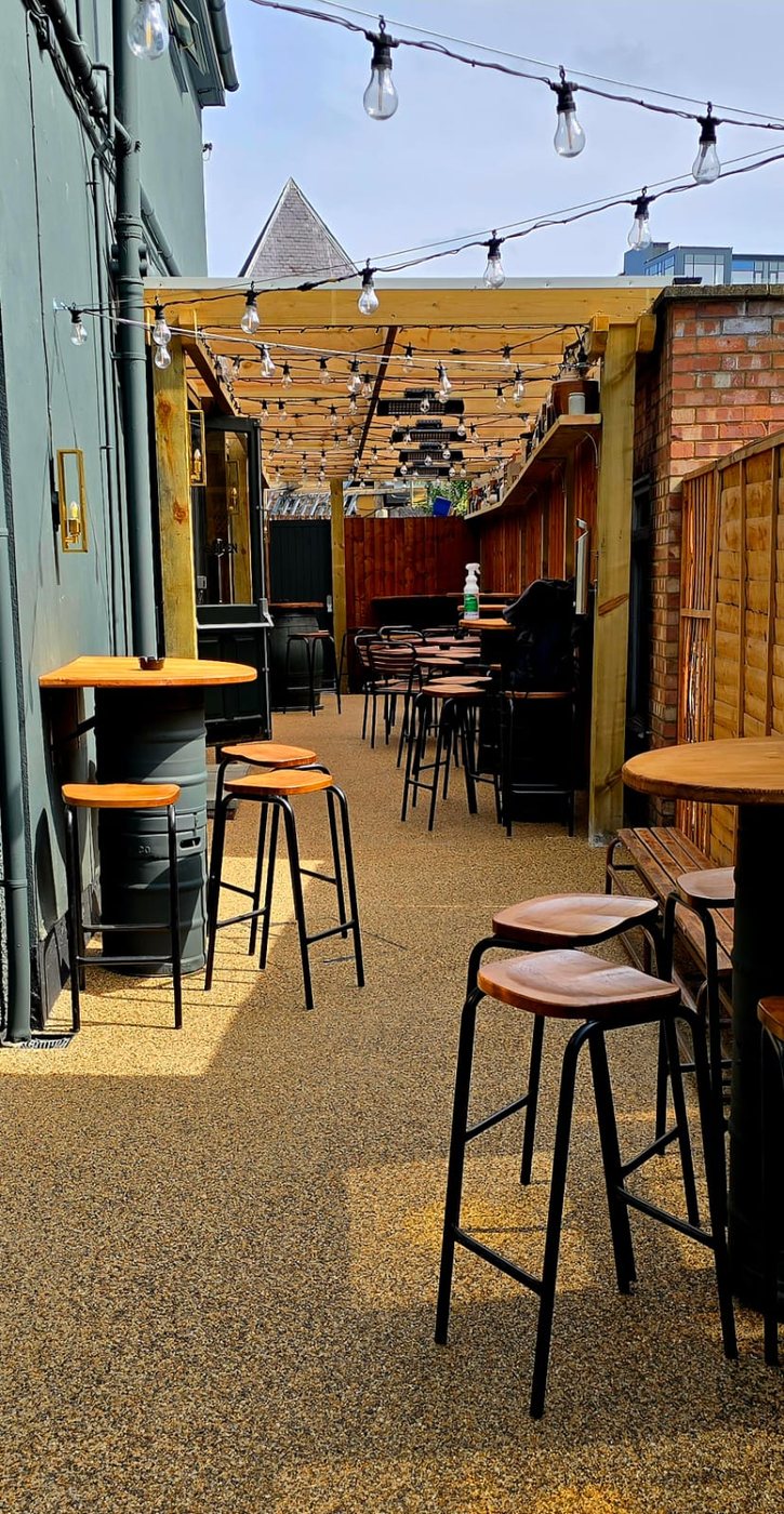 The courtyard: high tables and stools under strings of festoon lights