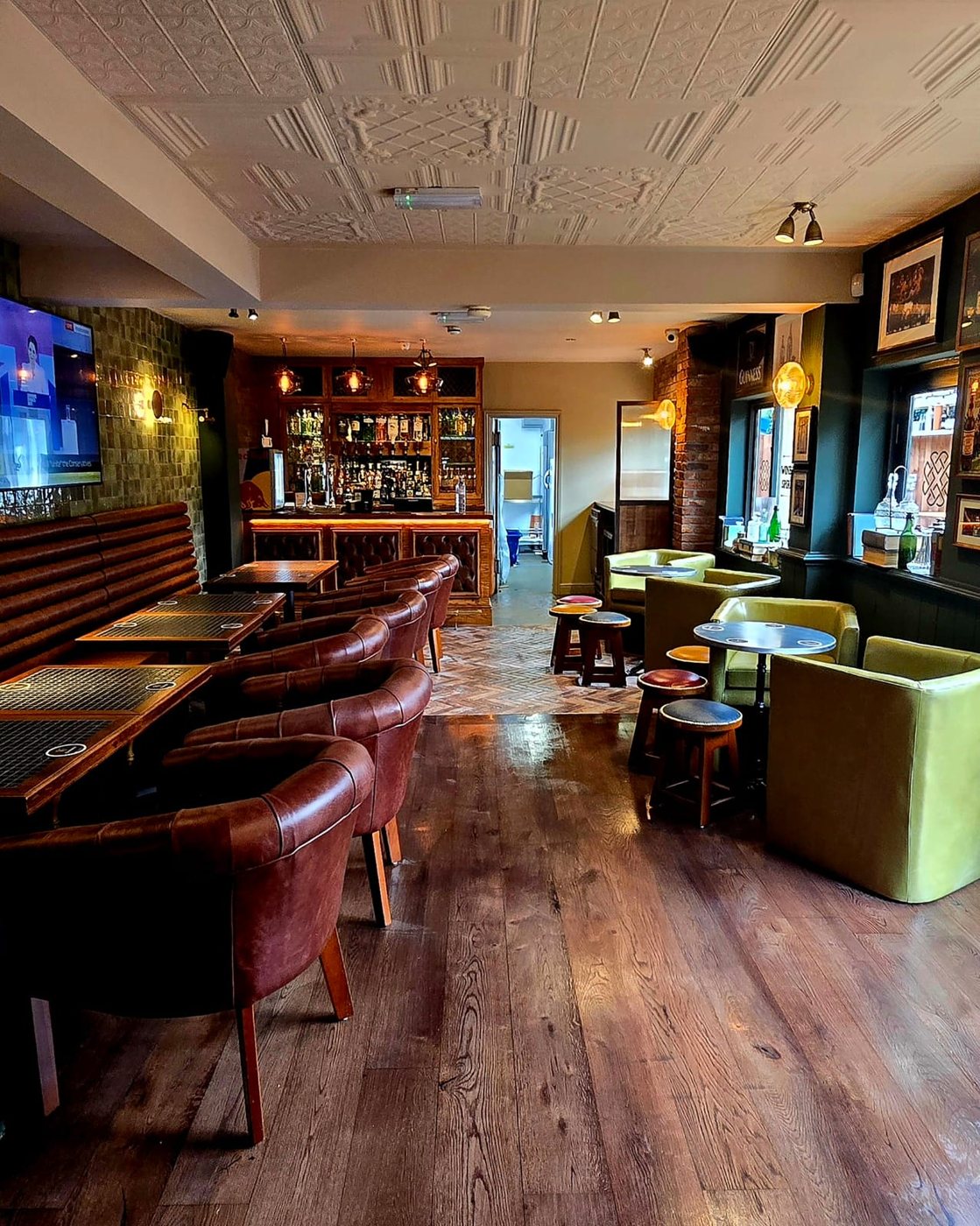The lounge: leather chairs along the tables, lime tub chairs and the bar at the far end